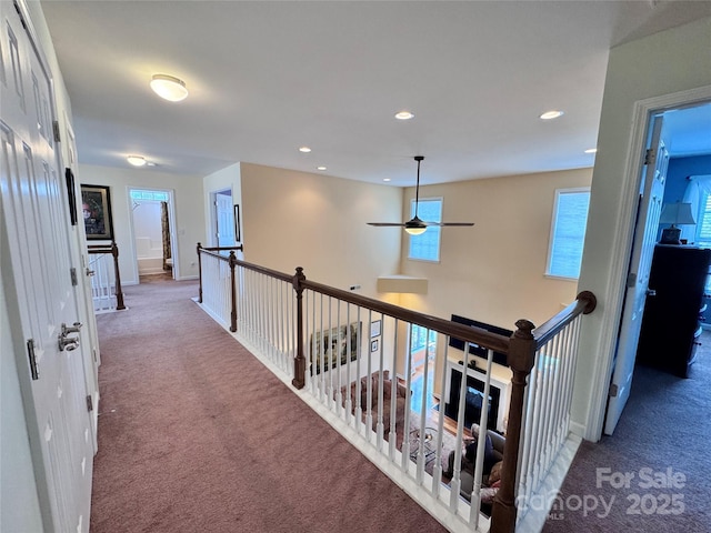 corridor featuring carpet and an upstairs landing