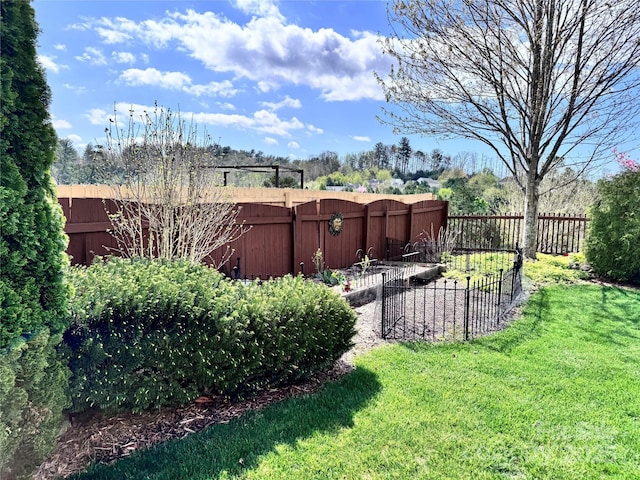 view of yard with a vegetable garden and a fenced backyard