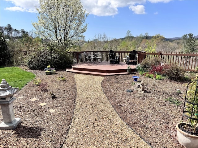 view of yard featuring a wooden deck and fence