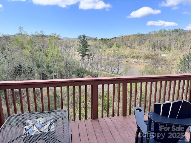 wooden deck featuring a view of trees and a water view