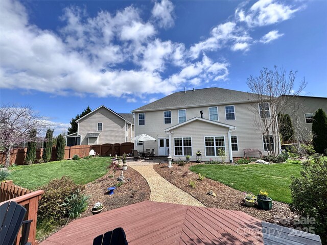 rear view of house featuring a yard, a patio, fence, and a deck