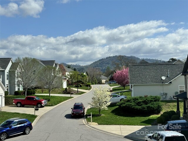 view of road featuring a residential view, curbs, and a mountain view