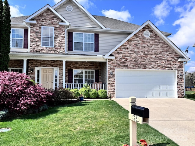 view of front facade with a front lawn, driveway, stone siding, covered porch, and a garage