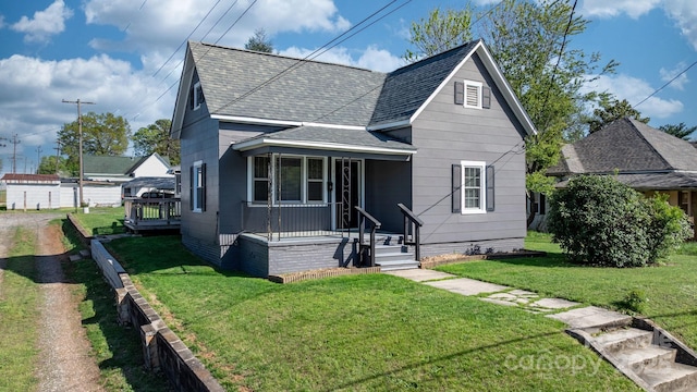 bungalow-style house featuring a front yard, a porch, and a shingled roof