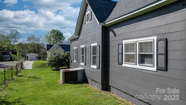 view of home's exterior with roof with shingles, fence, crawl space, a yard, and central AC unit