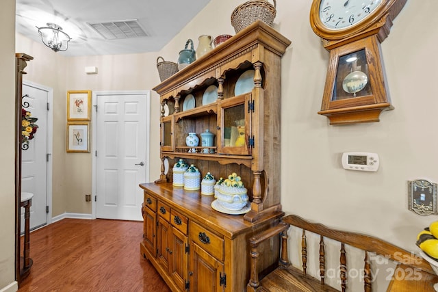 corridor with baseboards, dark wood-style floors, and visible vents