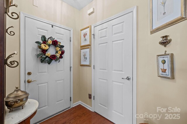 entryway featuring dark wood-style flooring and baseboards