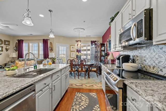 kitchen featuring stainless steel appliances, a wealth of natural light, white cabinetry, and a sink