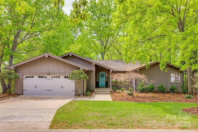 view of front of home featuring an attached garage, driveway, and a front lawn
