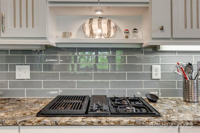 room details featuring stone countertops, tasteful backsplash, black gas stovetop, and open shelves