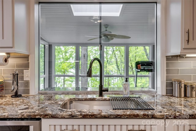 kitchen with wine cooler, decorative backsplash, ceiling fan, and a wealth of natural light