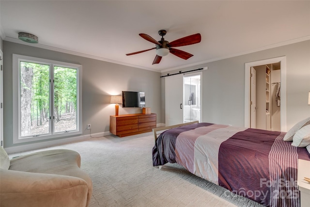 bedroom featuring crown molding, carpet floors, and a barn door