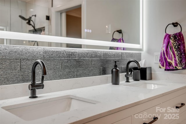 interior details featuring double vanity, a sink, and backsplash