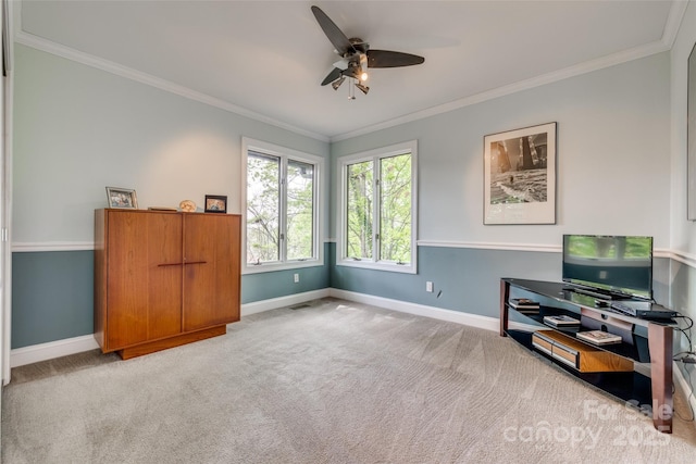interior space with ornamental molding, baseboards, a ceiling fan, and carpet