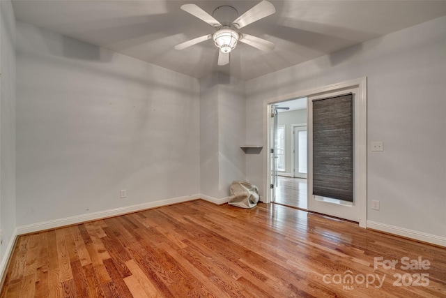 empty room featuring baseboards, a ceiling fan, and wood finished floors