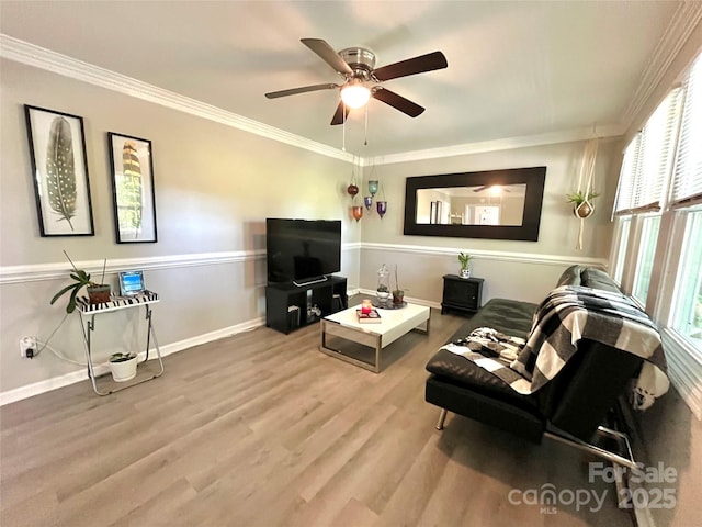 living area featuring baseboards, a ceiling fan, wood finished floors, and ornamental molding