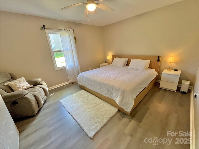bedroom featuring wood finished floors, baseboards, and ceiling fan