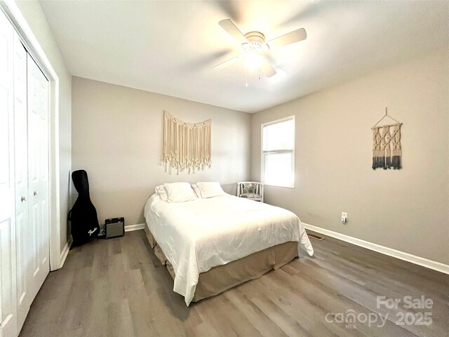 bedroom with wood finished floors, a closet, a ceiling fan, and baseboards