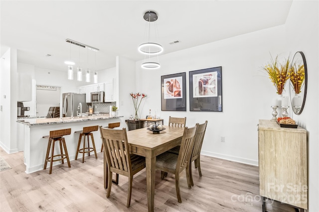 dining room with light wood-style floors and baseboards