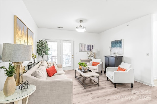 living area featuring light wood-style flooring and baseboards