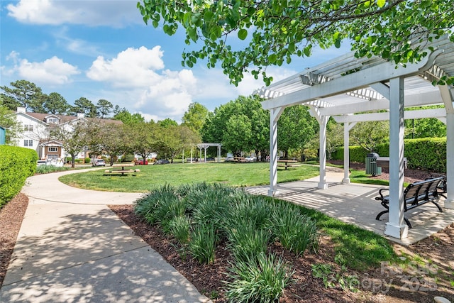 view of property's community featuring a pergola, a yard, and a patio