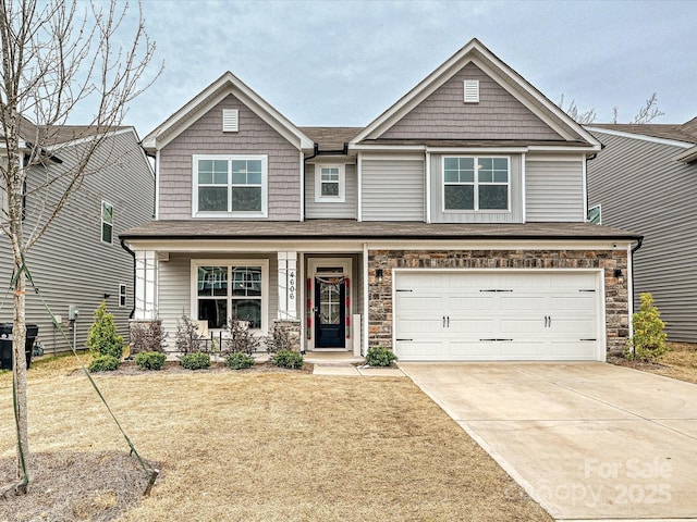 craftsman-style house featuring an attached garage, stone siding, covered porch, and concrete driveway
