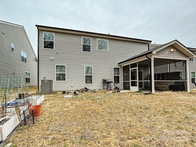 rear view of house featuring central air condition unit and a sunroom