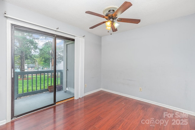 empty room with wood finished floors, baseboards, and a ceiling fan