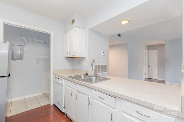 kitchen featuring a sink, light countertops, white appliances, white cabinetry, and dark wood-type flooring