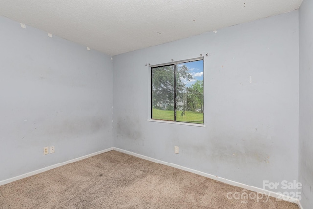 empty room with carpet and baseboards