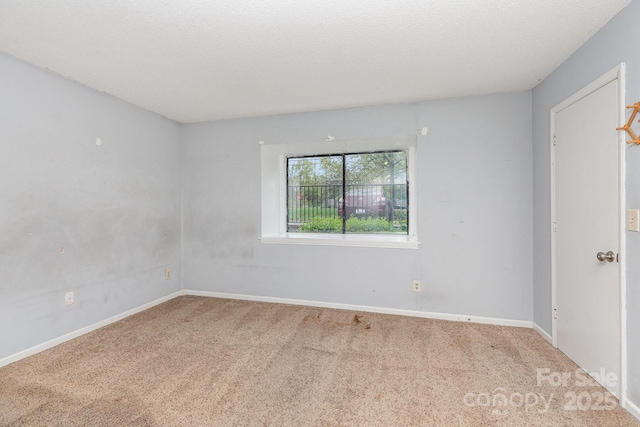 unfurnished room with carpet flooring and baseboards