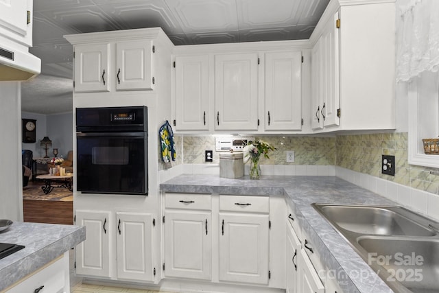 335 Ridgewood Dr, Mount Ulla, NC 28125 - kitchen featuring decorative backsplash, a sink, black oven, and white cabinets