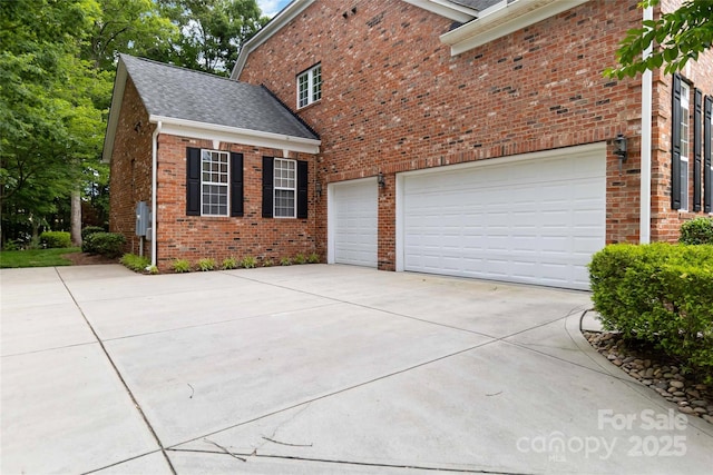 7302 Yellowhorn Trl, Waxhaw, NC 28173 - view of side of home featuring driveway, brick siding, a shingled roof, and a garage