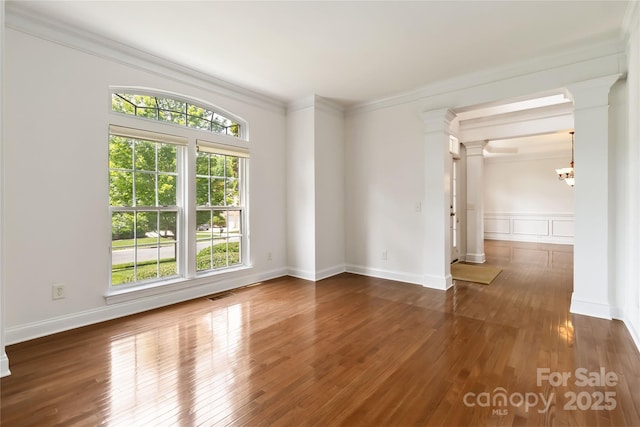7302 Yellowhorn Trl, Waxhaw, NC 28173 - unfurnished room with ornate columns, healthy amount of natural light, wood finished floors, and ornamental molding