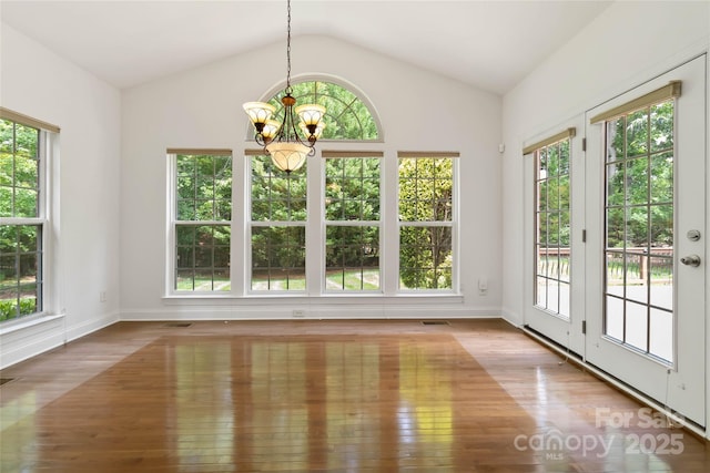 7302 Yellowhorn Trl, Waxhaw, NC 28173 - unfurnished sunroom with french doors, a chandelier, wood finished floors, plenty of natural light, and vaulted ceiling