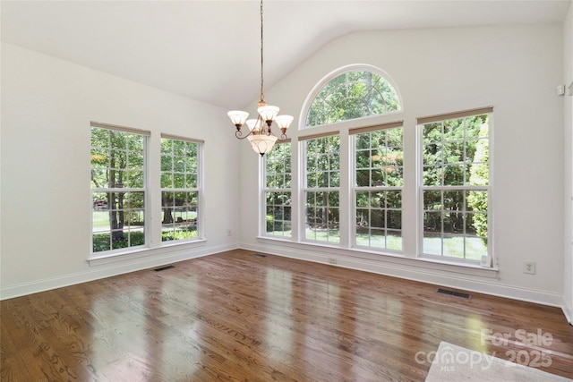 7302 Yellowhorn Trl, Waxhaw, NC 28173 - unfurnished dining area featuring a chandelier, vaulted ceiling, plenty of natural light, and wood finished floors