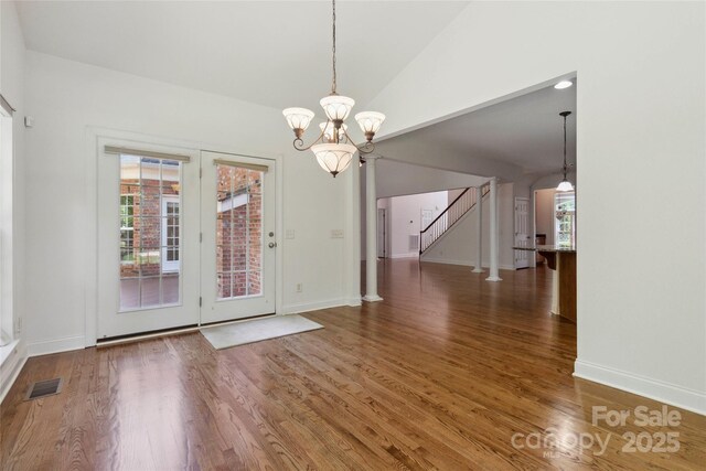 7302 Yellowhorn Trl, Waxhaw, NC 28173 - unfurnished dining area with wood finished floors, stairway, a chandelier, and lofted ceiling