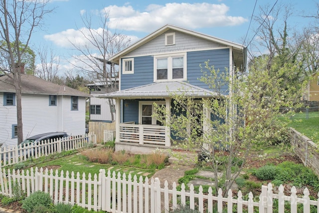 traditional style home with covered porch and a fenced front yard