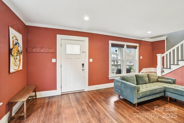 foyer with stairway, ornamental molding, and wood finished floors