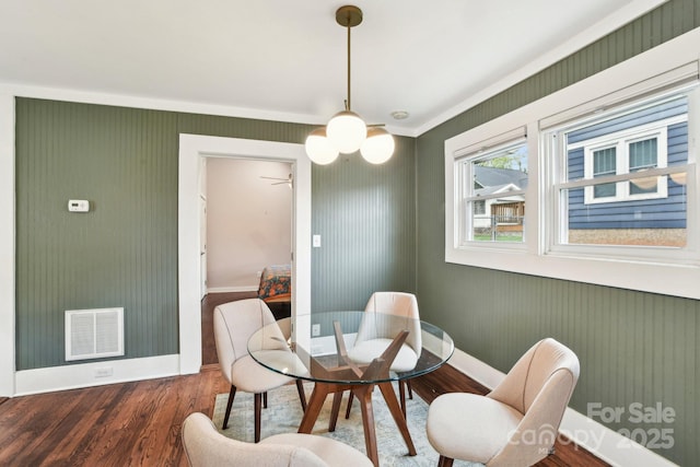 dining room featuring wood finished floors, baseboards, and visible vents