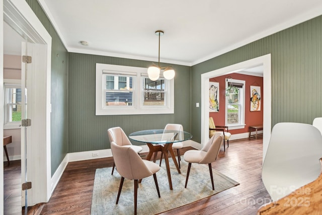 dining area featuring crown molding, wood finished floors, and baseboards