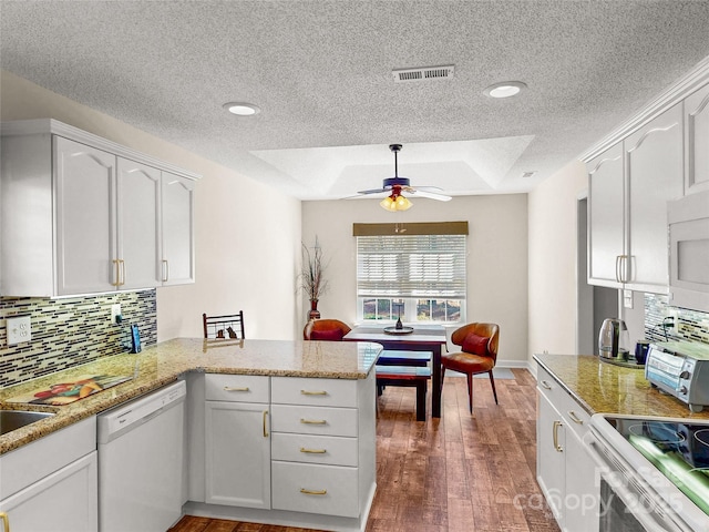 115 Keswick Ln, Mooresville, NC 28117 - kitchen with a peninsula, a textured ceiling, visible vents, white appliances, and ceiling fan