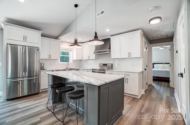 3612 Cobbleridge Dr, Charlotte, NC 28215 - kitchen featuring appliances with stainless steel finishes, wall chimney exhaust hood, white cabinetry, lofted ceiling, and recessed lighting