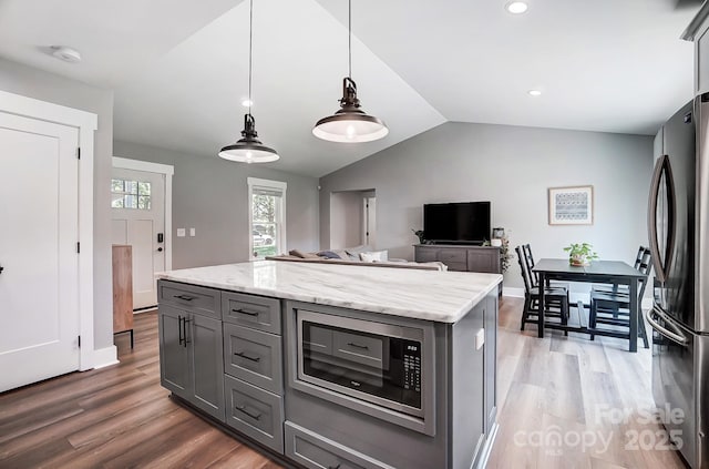 3612 Cobbleridge Dr, Charlotte, NC 28215 - kitchen with gray cabinetry, stainless steel appliances, lofted ceiling, light wood-type flooring, and hanging light fixtures