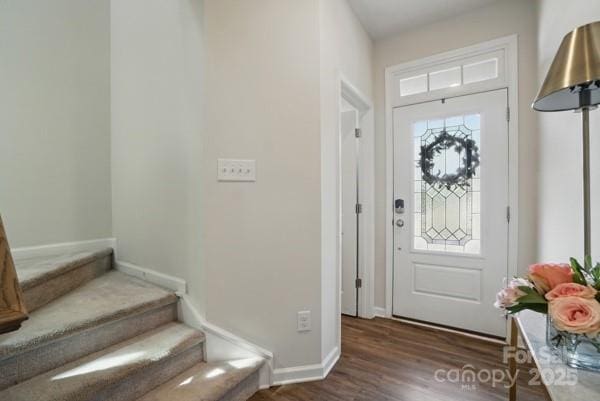 entrance foyer with baseboards, wood finished floors, and stairs