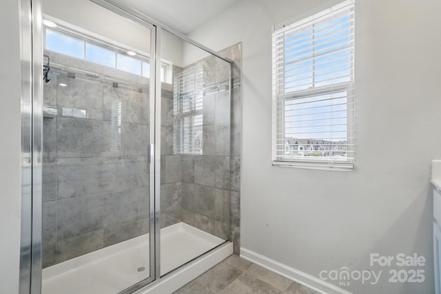 full bathroom featuring plenty of natural light, baseboards, tile patterned flooring, and a stall shower