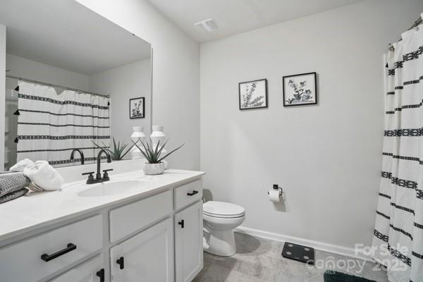 full bathroom with baseboards, vanity, curtained shower, and toilet