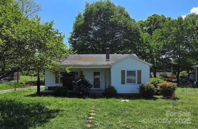 view of front facade with a front lawn, fence, and covered porch
