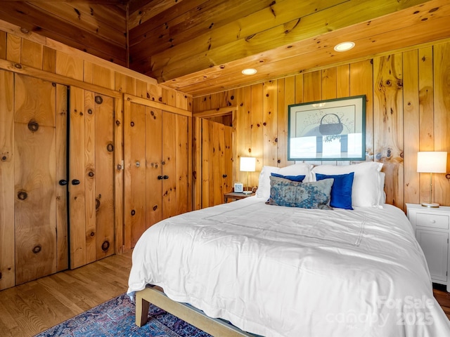 bedroom with wood finished floors, wood walls, and wooden ceiling