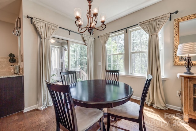dining room featuring baseboards, wood finished floors, and a chandelier